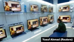 Seorang pengunjung melihat layar televisi di sebuah pusat perbelanjaan di Makassar, Sulawesi Selatan, 5 Februari 2013, sebagai ilustrasi. (Foto: REUTERS/Yusuf Ahmad)