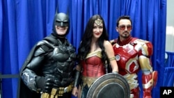 Armando Abarca, dressed as Batman, left, and Jessica Rose Davis, dressed as Wonder Woman, center, of Los Angeles, and Guillermo Gonzalez, of Sacramento, Calif., dressed as Iron Man, attend day one of Comic-Con International on Thursday, July 19, 2018, in San Diego.(Photo by Chris Pizzello/Invision/AP)