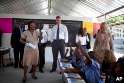 U.S. Secretary of Education Arne Duncan, center, stands in a classroom during his visit to the National School in Tabarre, Haiti, Nov. 5, 2013.