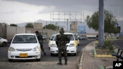 Policija zaustavlja automobile kod kontrolnog punkta blizu američke ambasade u Sani, u Jemenu, 6. avgusta 2013.