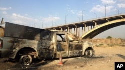 Một chiếc xe của cảnh sát Iraq bị cháy được bỏ lại trên một con đường trong thành phố Mosul