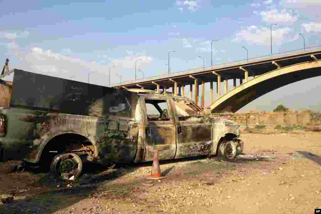 An Iraqi police truck is seen burned on a street in the northern city of Mosul, Iraq, July 6, 2014.