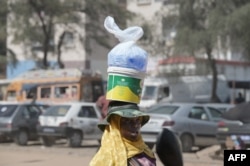 FILE - A vendor sells plastic sachets filled with drinkable water in Dakar, on August 25, 2023.