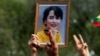 A person holds a picture of leader Aung San Suu Kyi as Myanmar citizens protest against the military coup in front of the U.N. office in Bangkok, Thailand, Feb. 22, 2021.