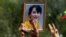 A person holds a picture of leader Aung San Suu Kyi as Myanmar citizens protest against the military coup in front of the UN office in Bangkok, Thailand Feb. 22, 2021.