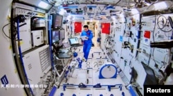 Chinese astronaut Tang Hongbo of the Shenzhou-12 mission works inside the core module Tianhe of the Chinese space station, in this image released by China Manned Space Engineering Office, Aug. 20, 2021.