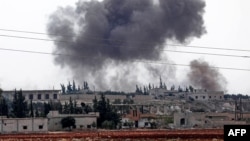 صوبہ ادلب کے ایک نواحی قصبے پر شامی فوج کی بمباری کے بعد دھواں اٹھ رہا ہے۔