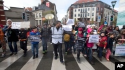An organizer leads children holding signs out of the Molenbeek district during a march against hate in Brussels on April 17, 2016. A new art museum has opened its doors in Brussels' Molenbeek district hoping to help shed the negative image of the area.