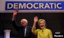 Democratic U.S. presidential candidates Senator Bernie Sanders and former Secretary of State Hillary Clinton arrive on stage ahead of the start of the PBS NewsHour Democratic presidential candidates debate in Milwaukee, Wisconsin, Feb. 11, 2016.