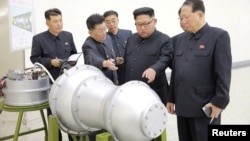 북한 김정은 노동당 위원장이 '핵무기 병기화 사업'을 현지지도했다고 조선중앙통신이 지난해 9월 보도했다. 뒤에 세워둔 안내판에 북한의 ICBM급 장거리 탄도미사일로 추정되는 '화성-14형'의 '핵탄두(수소탄)'라고 적혀있다.