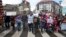 An organizer leads children holding signs out of the Molenbeek district during a march against hate in Brussels on April 17, 2016. A new art museum has opened its doors in Brussels' Molenbeek district hoping to help shed the negative image of the area.