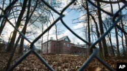 FILE - A fence encloses an estate in the village of Upper Brookville in the town of Oyster Bay, N.Y., on Long Island.