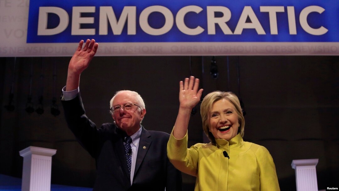 Senator Bernie Sanders (kiri) dan Hillary Clinton ketiba tiba untuk berdebat hari Kamis (11/2) malam di Milwaukee, Wisconsin.