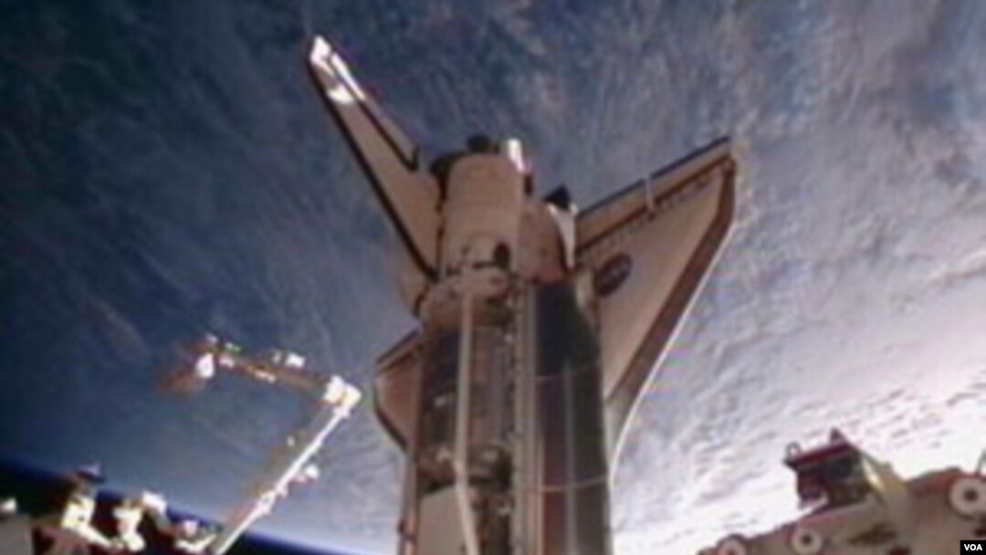 Gambar dari NASA TV ini menunjukkan Discovery merapat di landasan Stasiun Antariksa Internasional, Sabtu (26/2).