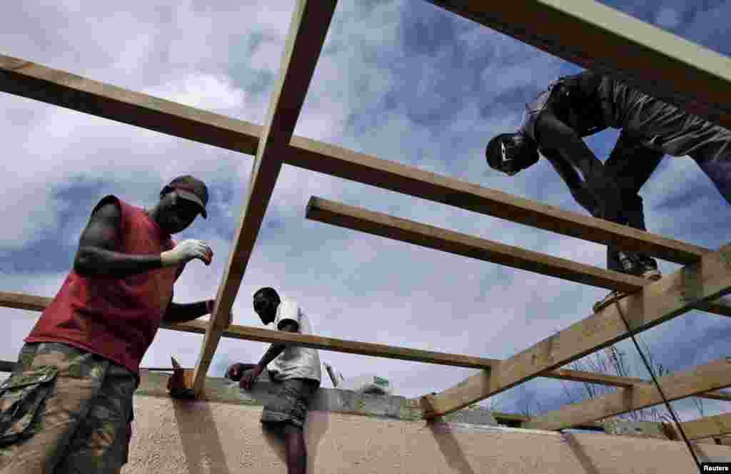 Workers repair the roof of a holiday resort days after Cyclone Pam, in Port Vila, March 19, 2015.