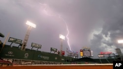 FILE - Lightning strikes over Fenway Park in Boston delay a baseball game between the Boston Red Sox and the Toronto Blue Jays, Sept. 6, 2014.