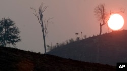 The sun sets near Pailin, Cambodia, in this Thursday March 10, 2005 photo, in an area hard hit by deforestation. (AP Photo/David Longstreath)