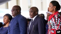 Congolese President Felix Tshisekedi, second left, his wife Denise Nyekeru, outgoing president Jospeh Kabila and his wife Olive Lembe di Sita , listen to the national anthem during the inauguration ceremony, in Kinshasa Thursday Jan. 24, 2019. 