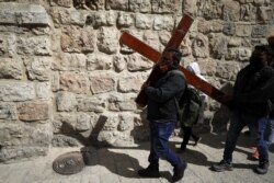 Umat Kristen dalam prosesi Jumat Agung di sepanjang Via Dolorosa di tengah pembatasan COVID-19, selama Pekan Suci Paskah di Kota Tua Yerusalem, 2 April 2021. (Foto: REUTERS/Ammar Awad)