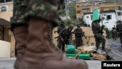 Brazilian soldiers and Civil Policemen carry drugs seized in the woods of Chatuba slum during an operation against drug dealers in Rio de Janeiro, Brazil, Aug. 22, 2018.