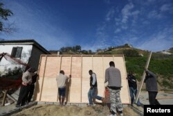Haitian migrants build a house in a neighborhood known locally as "Haitian Villa," where a family will live at Canon del Alacran in Tijuana, Mexico, Feb. 25, 2017.