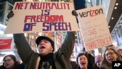 Demonstrators rally in support of net neutrality outside a Verizon store, Dec. 7, 2017, in New York. 