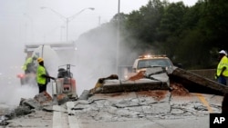 FILE - Construction crews work on a section of Interstate 20 West that buckled in Decatur, Georgia, April 17, 2017.