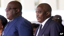 Congolese President Felix Tshisekedi, second left, his wife Denise Nyekeru, outgoing president Jospeh Kabila and his wife Olive Lembe di Sita , listen to the national anthem during the inauguration ceremony, in Kinshasa Thursday Jan. 24, 2019. 