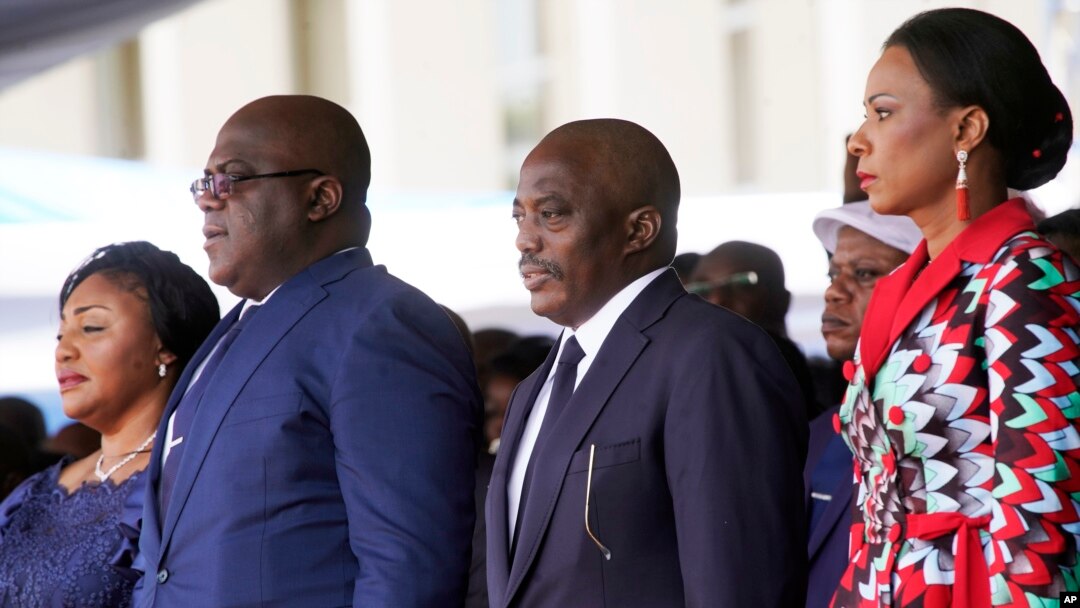 Congolese President Felix Tshisekedi, second left, his wife Denise Nyekeru, outgoing president Jospeh Kabila and his wife Olive Lembe di Sita , listen to the national anthem during the inauguration ceremony, in Kinshasa Thursday Jan. 24, 2019. 