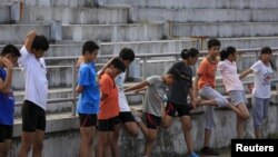 FILE - Youths attend a daily track-and-field class, part of a training course at the Jinshan Youth Spare-time Sports School, in Shanghai, Aug. 25, 2015. About 30 youths are enrolled and top performers will be groomed to become professional athletes.