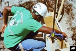 Student Fladimir Celunice checks to make sure his installation is level.