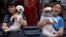 Animal activists hold a dog rescued from a dog meat trader (R) and a rescued stray dog, before a gathering against the Yulin Dog Meat Festival in Beijing, China, June 10, 2016.