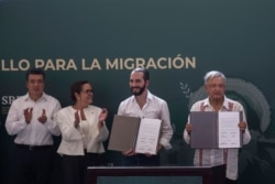 El Salvador President Nayib Bukele, second from right, and Mexican President Andres Manuel Lopez Obrador, right, show their signed agreements in Tapachula, Mexico, June 20, 2019