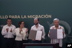El Salvador President Nayib Bukele, second from right, and Mexican President Andres Manuel Lopez Obrador, right, show their signed agreements in Tapachula, Mexico, June 20, 2019