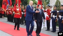 Outgoing European Commission President Jose Manuel Barroso, right, walks along the Guard of Honor as he is welcomed by Albanian Prime Minister Edi Rama in Tirana Monday, June 30, 2014. Albania was granted candidate status from the EU bloc last week. (AP P