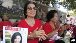 Supporters of Pheu Thai party cheer outside the parliament while Thai Prime Minister Yingluck Shinawatra delivers the government's policy speech at the parliament in Bangkok, Thailand, Aug. 23, 2011.