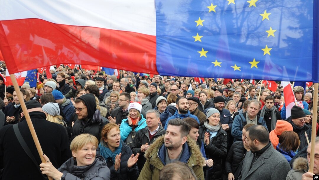 Protesters wave Polish and European Union flags during an anti-government demonstration in Warsaw, Poland, Dec. 19, 2015.
