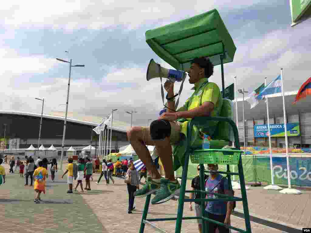 A worker uses a megaphone to get his point across to spectators at the Olympic Games in Rio de Janeiro, Brazil, Aug. 8, 2016. (P. Brewer/VOA)