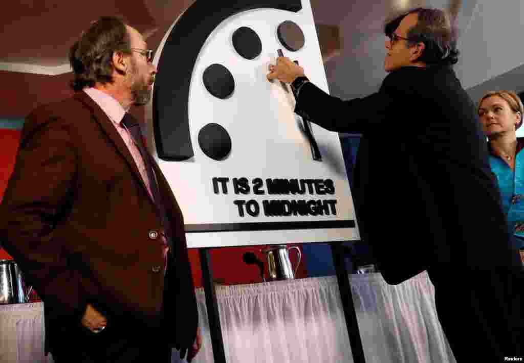 Members of the Bulletin of the Atomic Scientists, (L-R), Lawrence Krauss, Robert Rosner and Sharon Squassoni move the &#39;Doomsday Clock&#39; hands to two minutes until midnight at a news conference in Washington, due to world leaders&rsquo; poor response to threats of nuclear war.