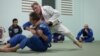 Chris Haueter (in white), one of the well-known BJJ trainers, shows a Jiu Jitsu's technique to a group of expats during a training session at the Olympic Stadium, in Phnom Penh, on February 22, 2016. (Neou Vannarin/VOA Khmer)