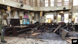 Foto yang dirilis oleh Angkatan Bersenjata WESMINCOM Filipina, seorang tentara memperhatikan ruang dalam gereja Katedral Katolik di Jolo, ibu kota Provinsi Sulu di selatan Filipina setelah dua bom meledak pada Minggu, 27 Januari 2019.