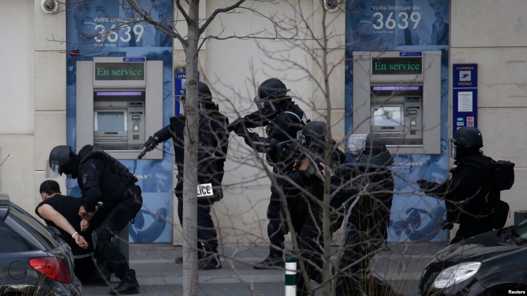 Seorang tersangka terkait penyanderaan di Paris ditangkap oleh polisi di luar kantor pos di Colombes, luar kota Paris (16/1).