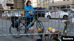 Kate Anstett, 22, wipes tears from her eyes by a makeshift memorial for victims of Tuesday's attack outside a police barricade on the bike path next to West Street in New York City, Nov. 1, 2017. 