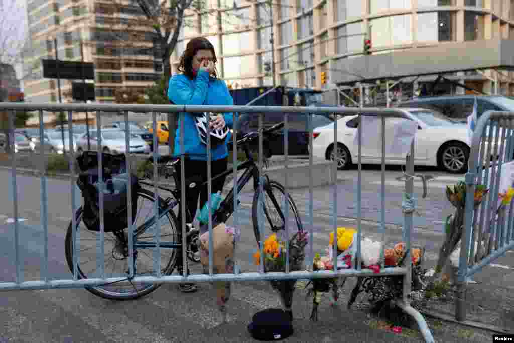 Kate Anstett, 22, wipes tears from her eyes by a makeshift memorial for victims of Tuesday&#39;s attack outside a police barricade on the bike path next to West Street in New York City, Nov. 1, 2017.