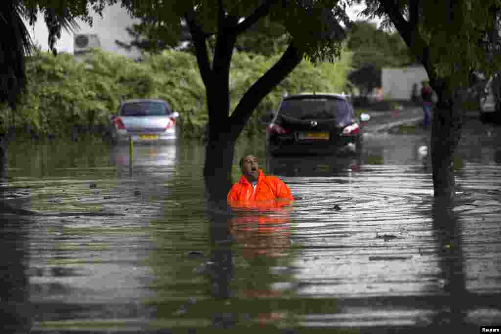 A municipality worker shouts as he tries to repair drainage on a flooded street in the southern city of Ashkelon, Israel.