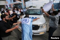 Palestinians try to block the convoy of United Nations Secretary-General Antonio Guterres upon his arrival near Erez crossing in the northern Gaza Strip, August 30, 2017.