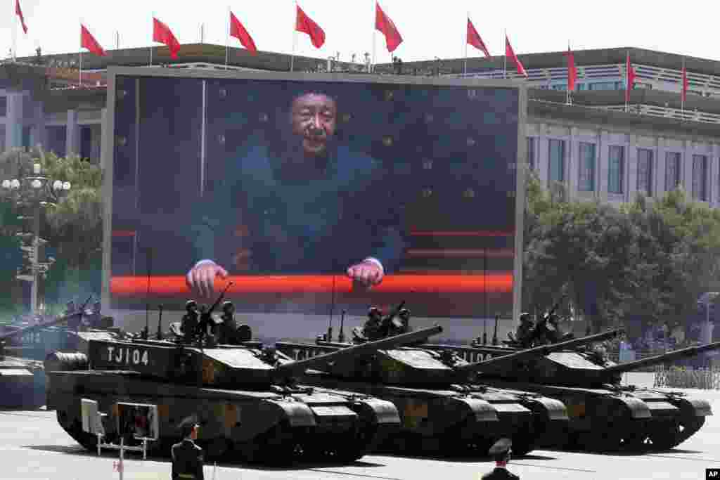 Đoàn xe tăng Trung Quốc chạy ngang màn ảnh chiếu hình Chủ tịch Trung Quốc Tập Cận Bình theo dõi cuộc duyệt binh kỷ niệm lần thứ 70 ngày Nhật Bản đầu hàng trong Thế chiến thứ II, ngày 3/9/2015.