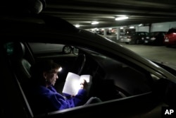 Ellen Tara James-Penney, a lecturer at San Jose State University, prepares her lesson plan inside the station wagon where she sleeps, Oct. 10, 2017, in San Jose, California.