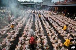 FILE - Ethnic-Chinese Indonesians arrange offerings for their ancestors' souls during the "hungry ghost" festival in Medan, North Sumatra, Indonesia, Aug. 10, 2014.