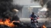Un motociclista conduce a través de una barricada en llamas, en uno de los varios vecindarios que los residentes se vieron obligados a abandonar debido a la escalada de la violencia, en Puerto Príncipe, Haití, el 18 de enero de 2024.